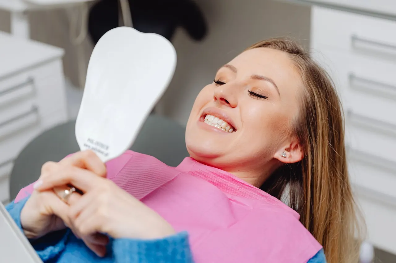 Centrum Medyczne Mariodent w Wąbrzeźnie — uśmiechnięta pacjentka i logo kliniki
